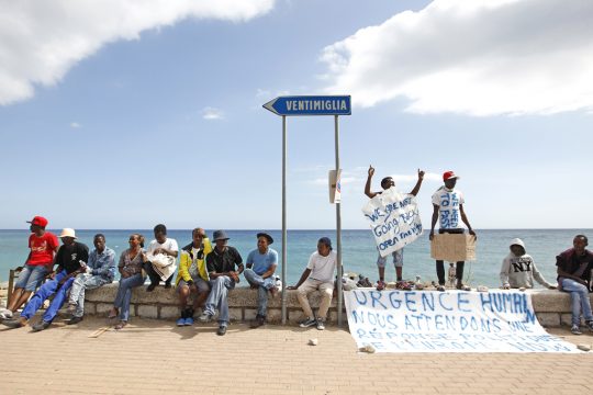 Migranten mit Plakaten in Ventimiglia an der französisch-italienischen Grenze