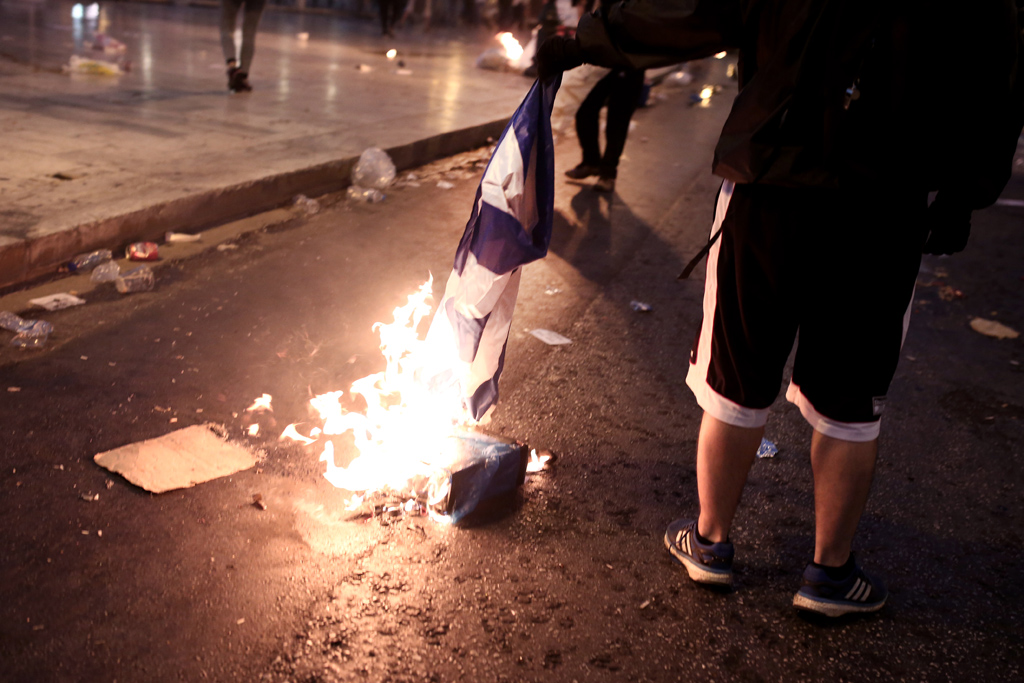 Demonstrant in Athen verbrennt die griechische Flagge