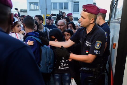 Ungarische Polizisten am Bahnhof von Bicske begleiten wartende Flüchtlinge