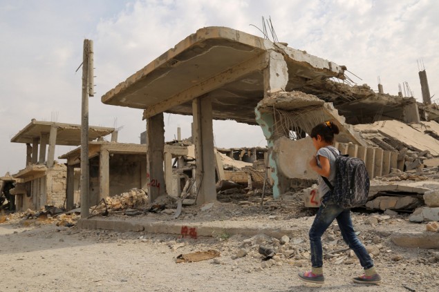 Syrisches Kind neben zerstörten Gebäuden in Kobane (6.10.)