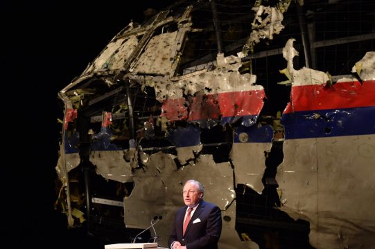 Tjibbe Joustra am Dienstag bei der Vorstellung des Abschlussberichtes: Im Hintergrund ist ein Wrackteil der MH17 zu sehen