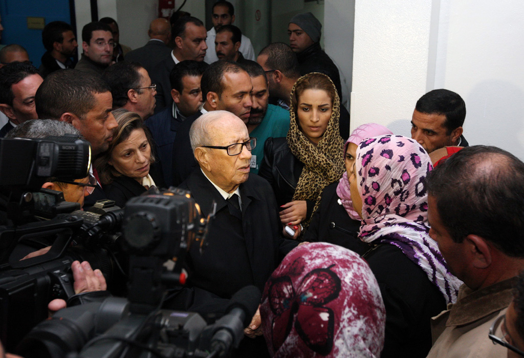 Tunesiens Staatschef Béji Caïd Essebsi (M.) mit Familienangehörigen der bei einem Anschlag verletzten Sicherheitsleute (24.11. in Tunis)