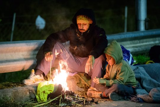 Flüchtlinge an der slowenisch-österreichischen Grenze wärmen sich an einem kleinen Lagerfeuer auf (4.11.)