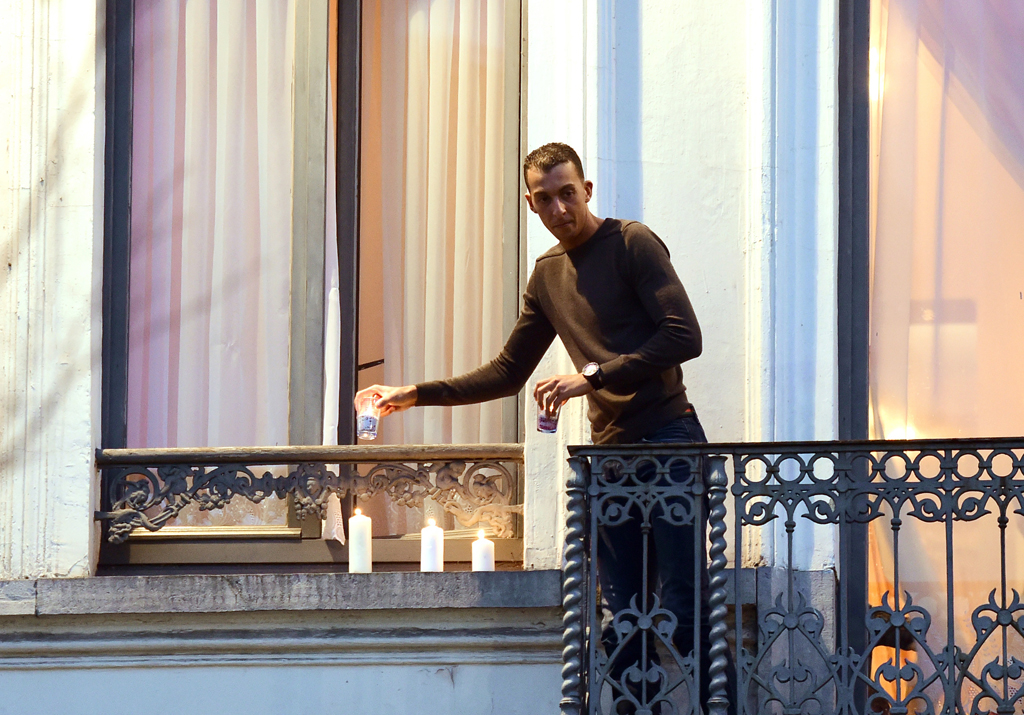 Bruder des gesuchten Salah Abdeslam, stellt Kerzen auf die Fensterbank seiner Wohnung in Molenbeek (18.11.)