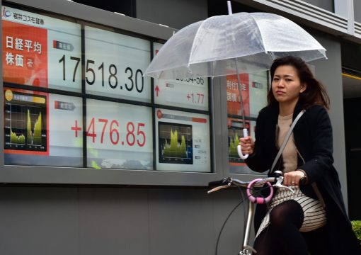 Frau vor einer Anzeigetafel mit Börsenresultaten in Tokio (29.1.)