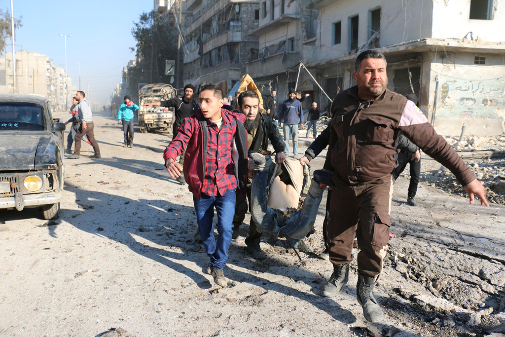 Aleppo nach einem Luftschlag am 8.2. - der leblose Körper eines Syrers wird weggetragen