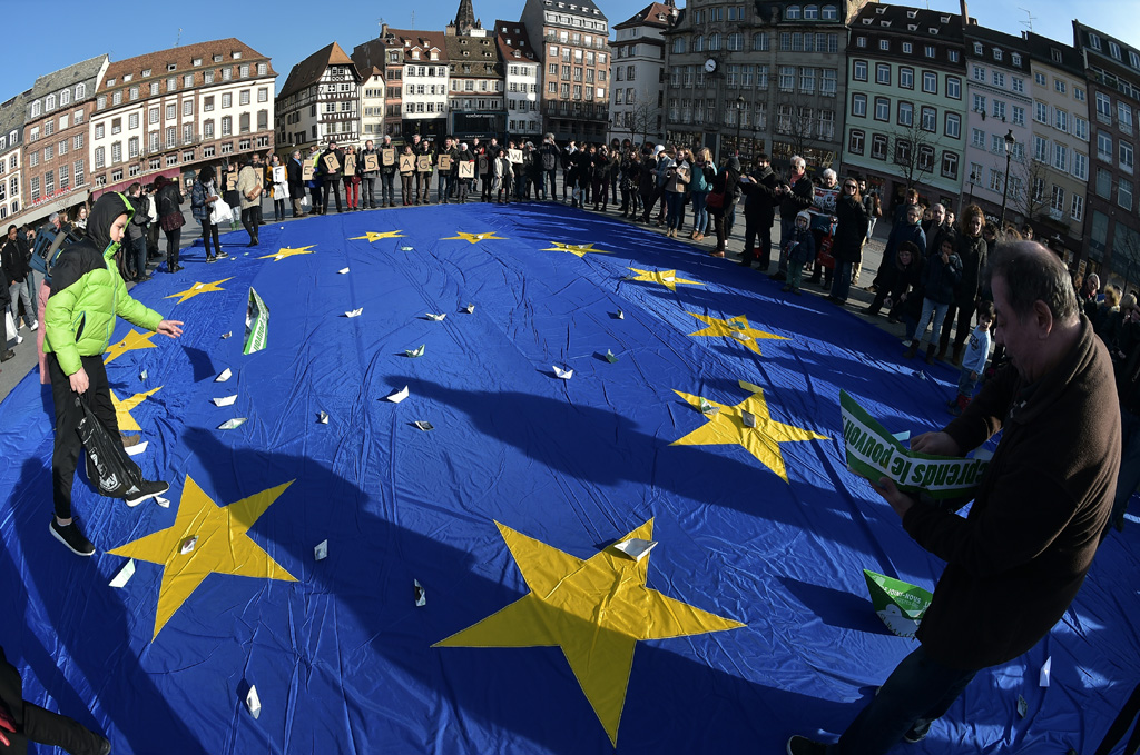 Menschen werfen Papierboote auf eine riesige Europa-Flagge in Straßburg (27.2.)