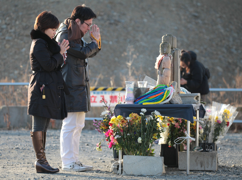 Japanisches Paar in Minamisanriku, Präfektur Miyagi, betet für die Opfer der Katastrophe vor fünf Jahren