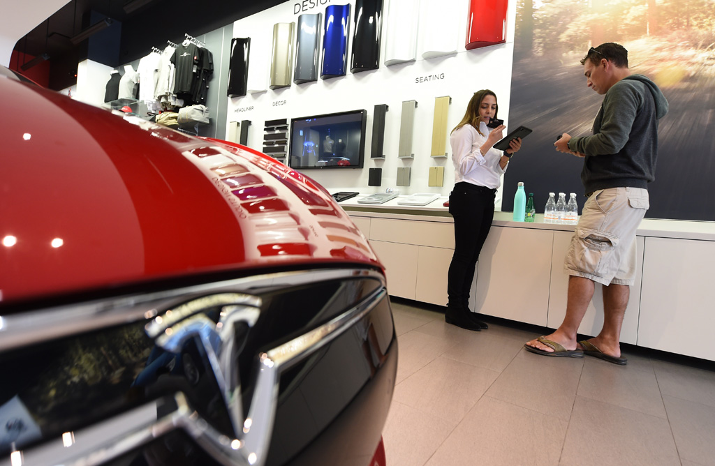 Verkäuferin in Santa Monica, Kaliforniern, hilft einem Kunden beim Reservieren eines Tesla "Model 3 (31.3.)