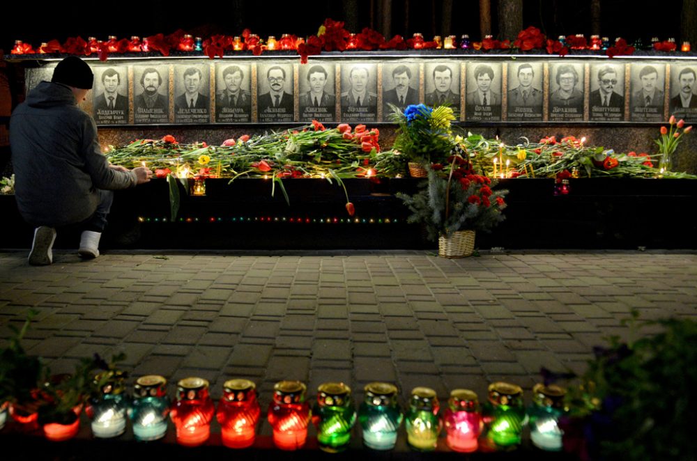 Mann legt Blumen vor dem Denkmal für die Tschernobyl-Opfer in Slavutich ab (26.4.)