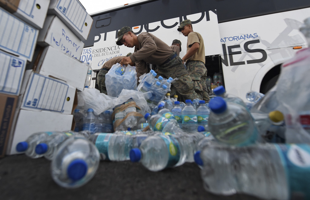 Soldaten laden Wasserflaschen in einen Bus, der das Trinkwasser nach Manta bringen soll