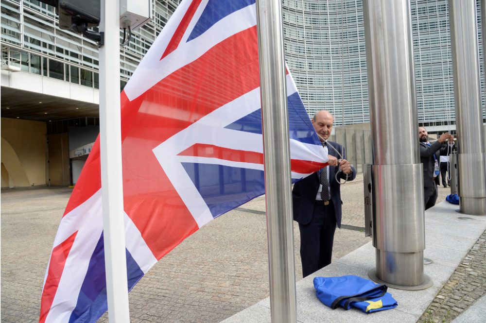 Mitarbeiter der EU-Kommission holt anlässlich des Gipfels die britische Flagge im Brüsseler EU-Viertel ein