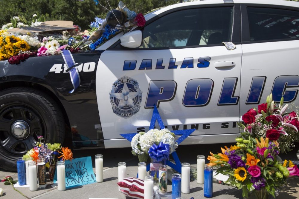 Blumen und Kerzn vor Polizeiwagen in Dallas