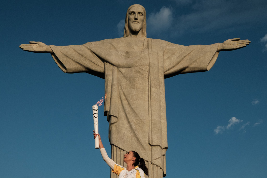 Die frühere Volleyballspielerin Maria Isabel Barroso Salgado mit dem olympischen Feuer vor der Christus-Statue auf dem Zuckerhut in Rio
