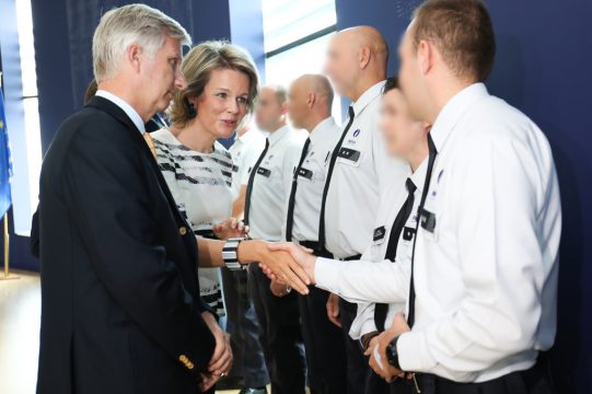 König Philippe und Königin Mathilden mit Beamten um Polizeikommissariat von Charleroi