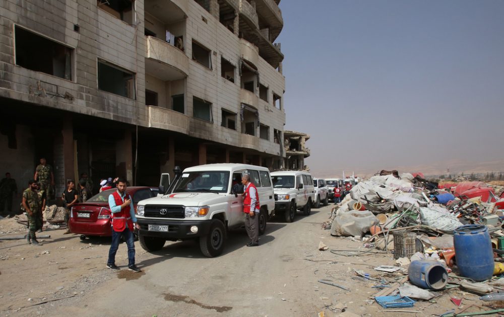 Ambulanzen des Roten Kreuzes und soldaten der syrischen Armee am Freitag in Daraja