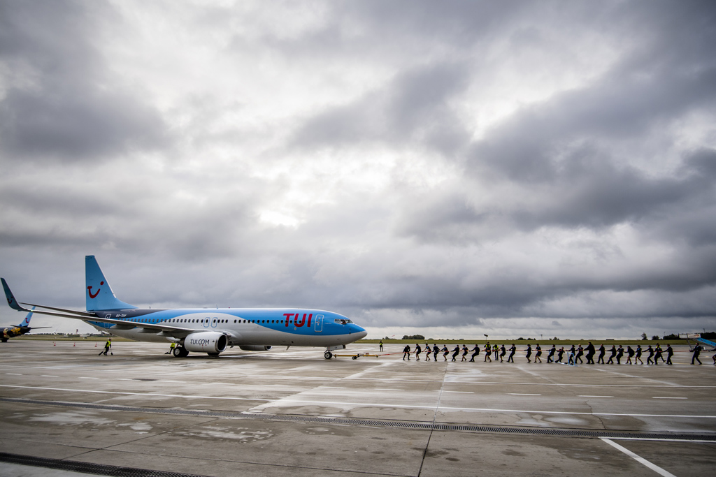 Symbolischer Akt: Flugbegleiter ziehen eine TUI-Maschine über das Rollfeld vom Flughafen Zaventem