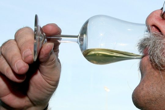 Älterer Herr nippt an einem Glas Whisky