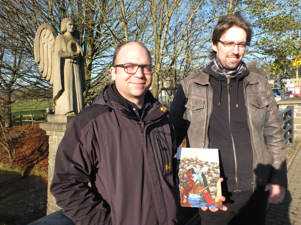 Autor Christophe Schommer und Zeichner René Heinen mit ihrem Comic auf der Engelsbrücke in Amel