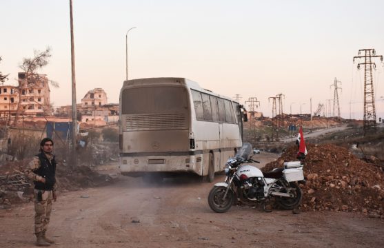 Im Rahmen der Evakuierungsmission in Aleppo fährt ein Bus durch die Vororte