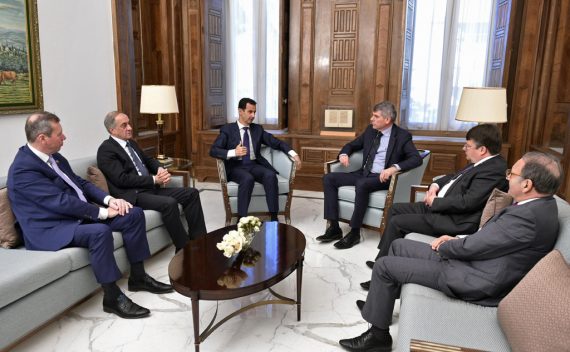 Stühle im Kreis, sechs Personen, darunter Syriens Machthaber Assad und Filip Dewinter