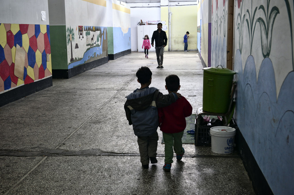 Flüchtlingskinder spazieen durch den Flur eines Flüchtlingslagers