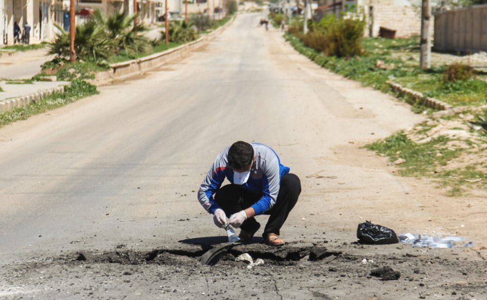 Ein Mann entnimmt Proben nach dem Giftgasanschlag in Syrien