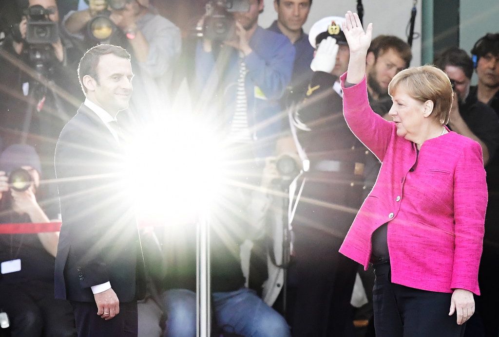 Der französische Präsident Emmanuel Macron und die deutsche Bundeskanzlerin Angela Merkel im Blitzlichtgewitter am Montag bei Macron's Antrittsbesuch in Berlin