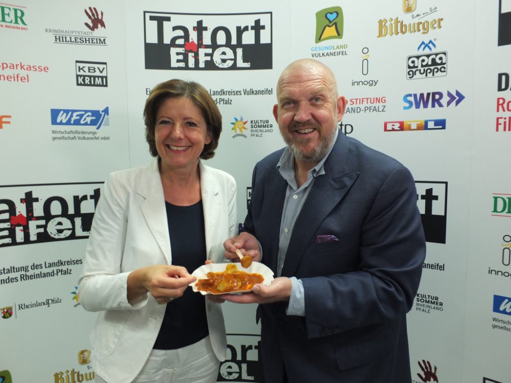 Dietmar Bär stilecht mit Currywurst (wie im Kölner Tatort) zusammen mit Malu Dreyer, Ministerpräsidentin von Rheinland-Pfalz