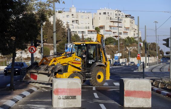Ein Bagger bringt Betonblöcke, mit denen die Straßen abgeriegelt werden.