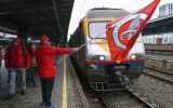 Gewerkschafter schwenkt im Bahnhof eine rote Flagge