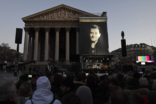 Menschen versammeln sich am 9.12.2017 vor der Madeleine-Kirche in Paris, um sich von Johnny Hallyday zu verabschieden(Bild: Eric Feferberg/AFP)