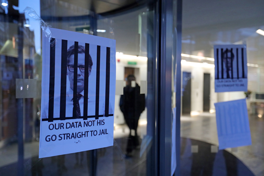 "Unsere Daten, nicht seine. Geh ins Gefängnis", ist auf dem Plakat zu lesen, das Alexander Nix zeigt (Bild: Daniel Leal-Olivas/AFP)