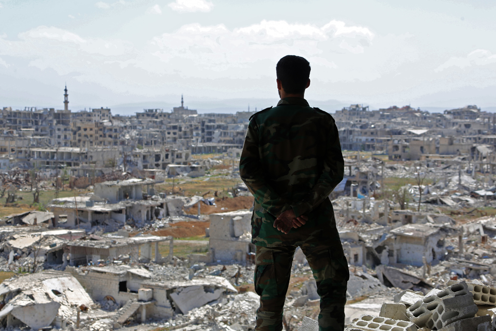 Syrischer Soldat blickt über das zu großen Teilen zerstörte Ost-Ghuta (Bild: STR/AFP)