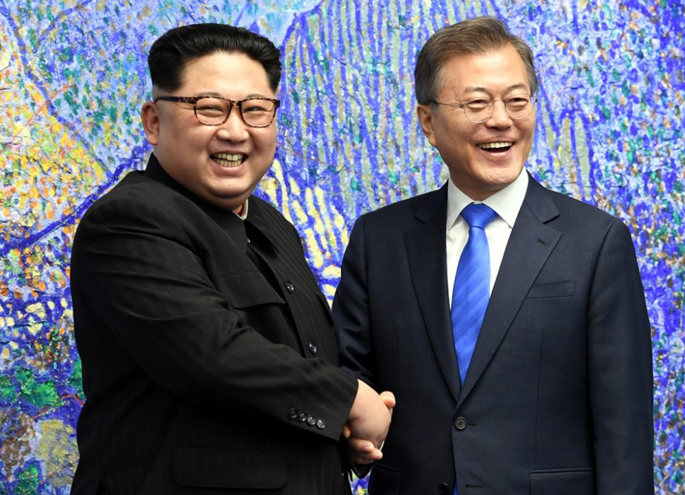 Kim (l.) und Moon reichen sich im Grenzdorf Panmunjom die Hände