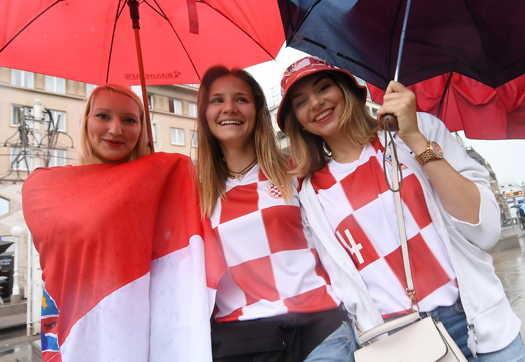 Der Regen kann den Kroaten trotzdem nicht die Laune verderben (Bild: Attila Kisbenedek/AFP)