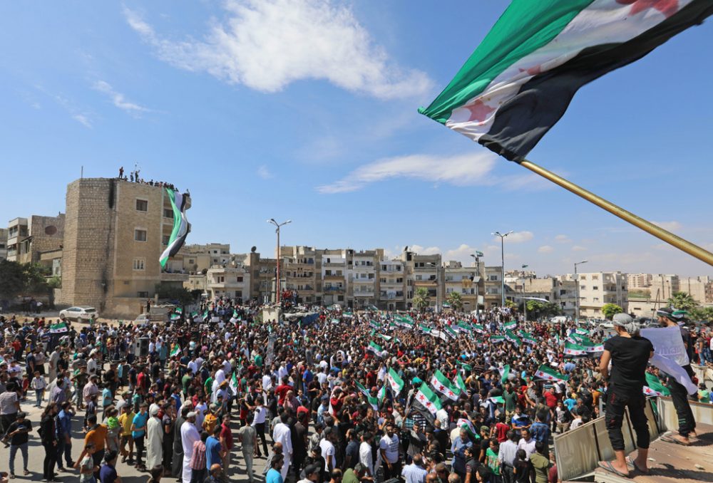 Syrische Demonstranten wehen die Flagge der Opposition am 7.9.2018 in der Stadt Idlib