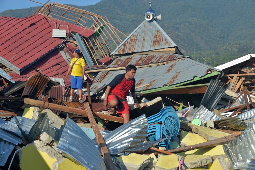 Indonesier durchsuchen am 1.10.2018 zerstörte Häuser in Palu