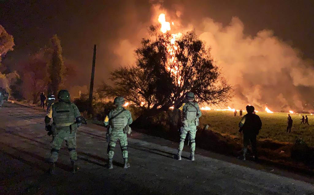 Nach Explosion einer Benzinleitung: Mexikanische Soldaten bewachen das Feuer
