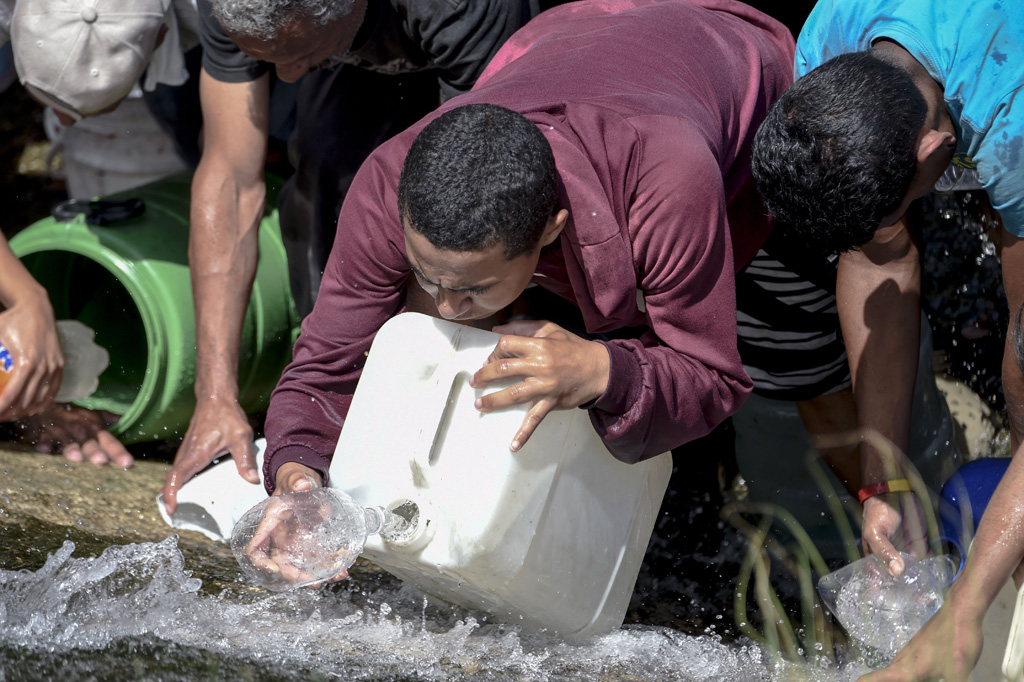 Stromausfall: Venezolaner schöpfen Wasser aus einem Kanal (Bild: Juan Barreto/AFP)