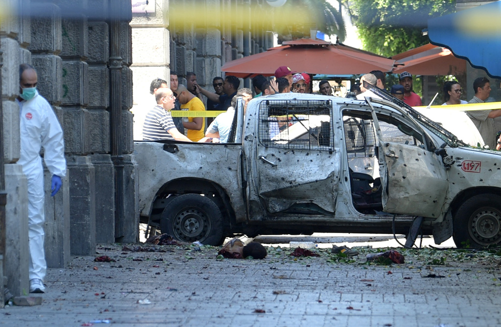 Nach Selbstmordanschlag in Tunis: Forensiker arbeitet neben zerstörtem Wagen (Bild: Fethi Belaid/AFP)