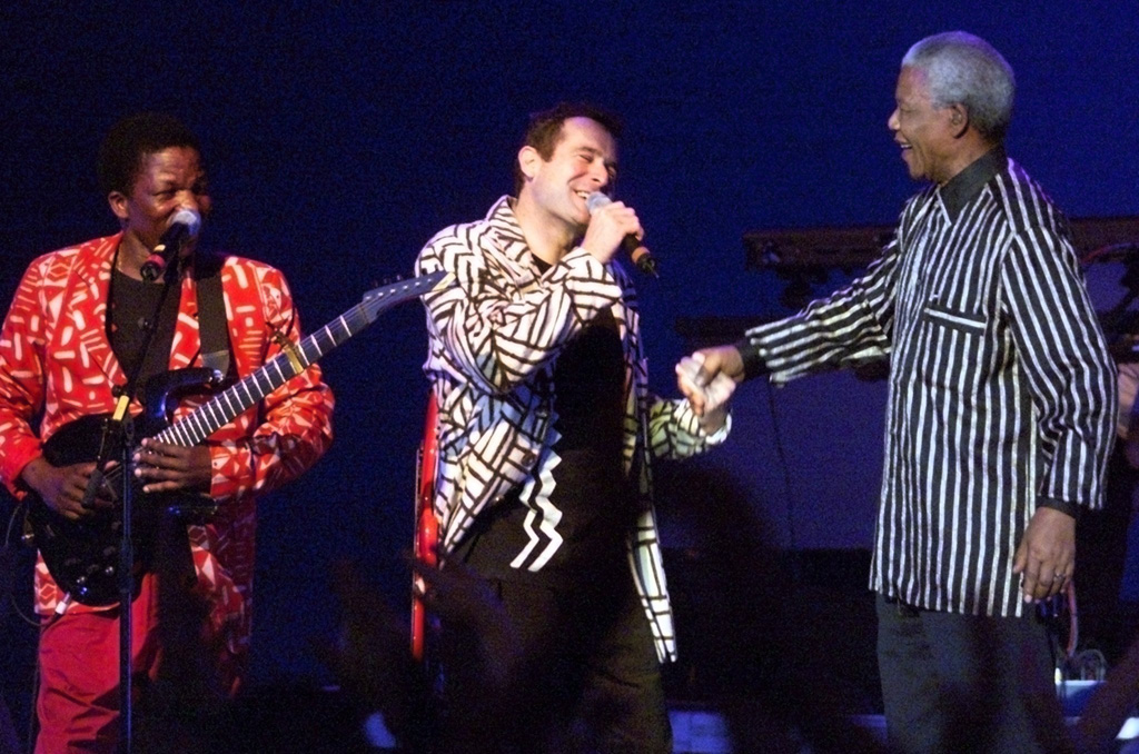 Johnny Clegg (Mitte) gemeinsam mit Nelson Mandela (r.) bei einem Konzert in Frankfurt im September 1999 (Bild: Oliver Berg/EPA)