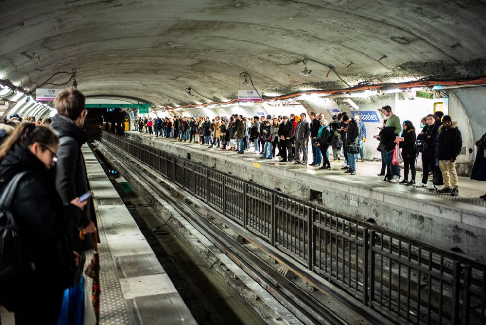 Pendler stehen an einem Pariser U-Bahnhof