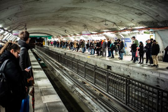 Pendler stehen an einem Pariser U-Bahnhof