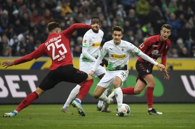 Moenchengladbach's German midfielder Florian Neuhaus (C) and Freiburg's German defender Robin Koch (L) vie for the ball during the German first division Bundesliga football match Borussia Moenchengladbach vs SC Freiburg in Moenchengladbach, western Germany on December 1, 2019. (Photo by INA FASSBENDER / AFP) / RESTRICTIONS: DFL REGULATIONS PROHIBIT ANY USE OF PHOTOGRAPHS AS IMAGE SEQUENCES AND/OR QUASI-VIDEO