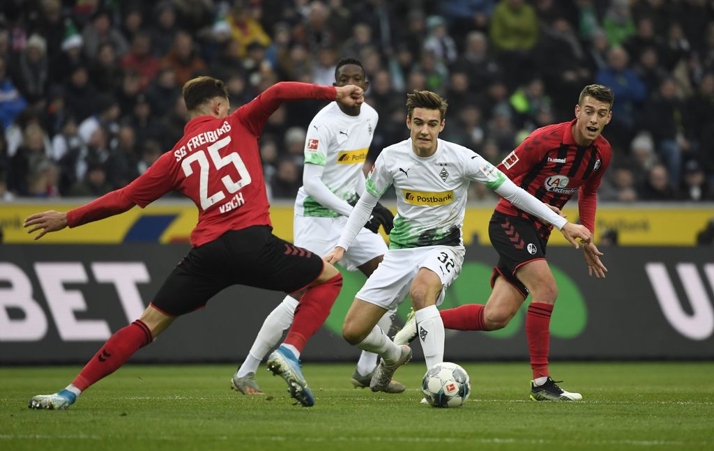 Moenchengladbach's German midfielder Florian Neuhaus (C) and Freiburg's German defender Robin Koch (L) vie for the ball during the German first division Bundesliga football match Borussia Moenchengladbach vs SC Freiburg in Moenchengladbach, western Germany on December 1, 2019. (Photo by INA FASSBENDER / AFP) / RESTRICTIONS: DFL REGULATIONS PROHIBIT ANY USE OF PHOTOGRAPHS AS IMAGE SEQUENCES AND/OR QUASI-VIDEO
