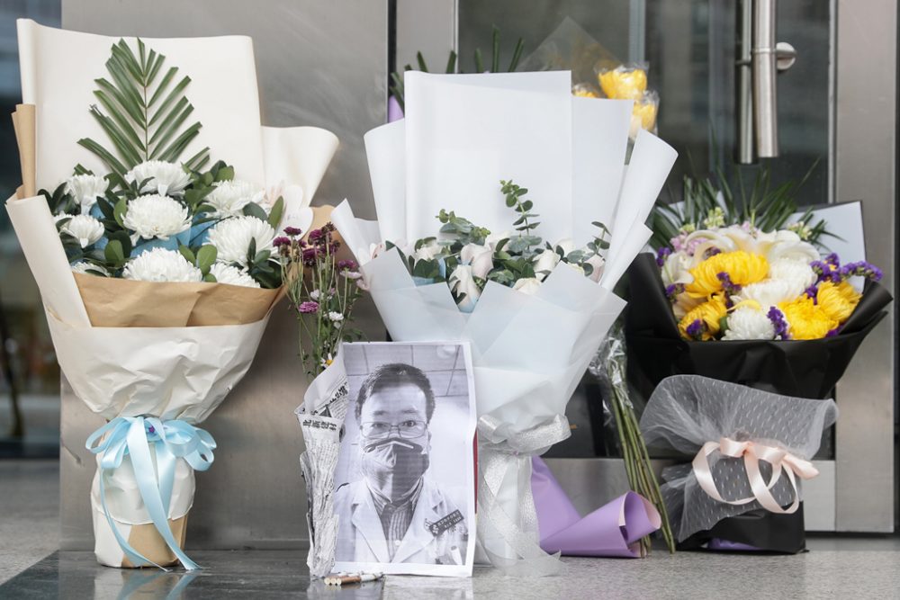 Blumen und ein Foto des chinesischen Arztes Li Wenliang in Wuhan (Bild: STR/AFP)