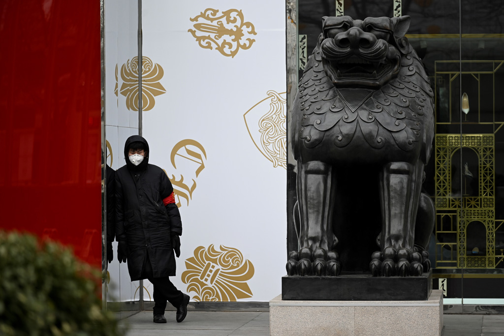 Sicherheitsmann mit Atemmaske vor einem Geschäft in Peking (Bild: Wang Zhao/AFP)