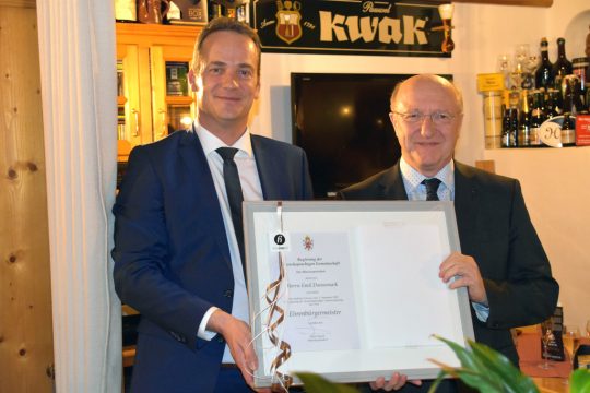 Emil Dannemark erhält die Ehrenurkunde von Ministerpräsident Oliver Paasch (Bild: Chantal Scheuren/BRF)