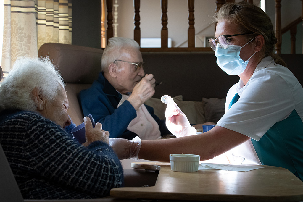 Pflegekraft mit chirurgischer Maske in Seniorenheim